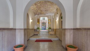 A grand hallway with a tiled floor, a red carpet, and two terracotta planters. - Selected & Private apARTment. Double check cleaning mode. Smart customer service (Roma)