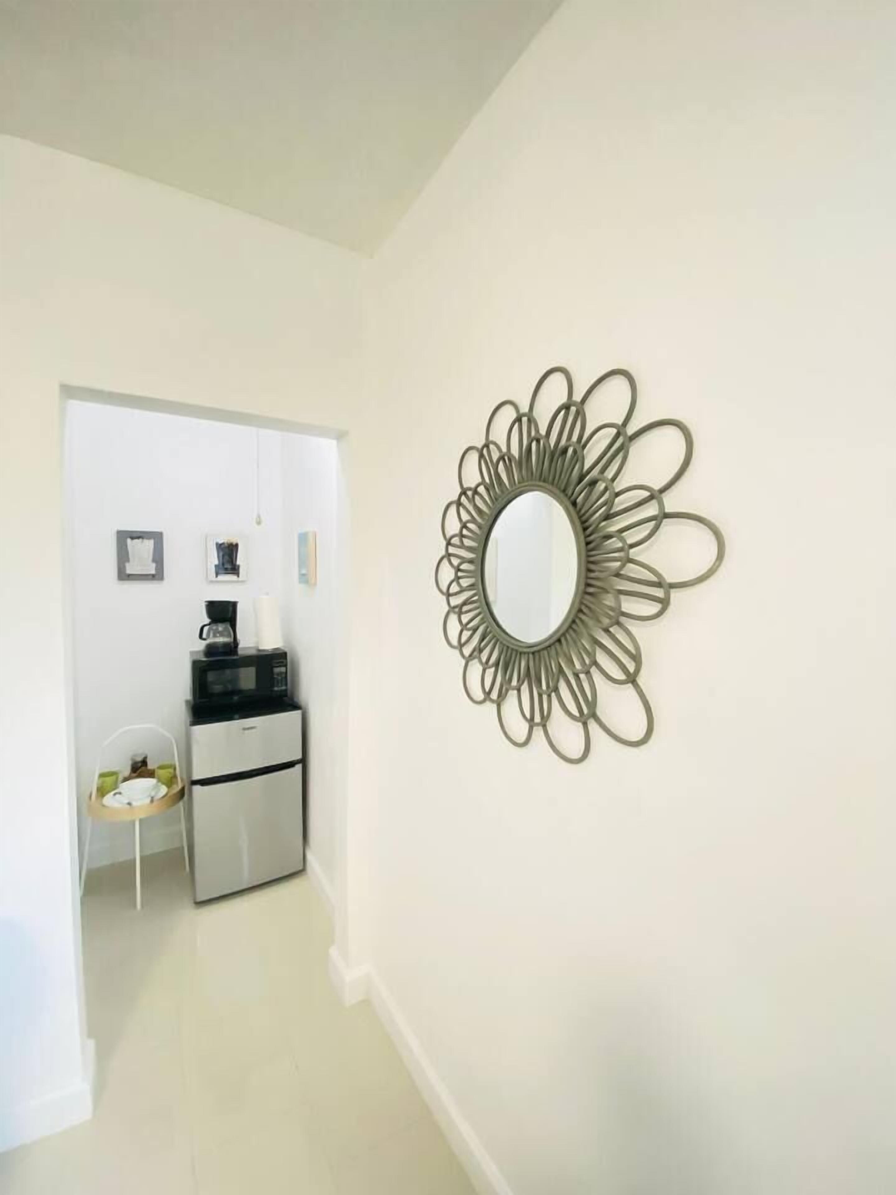 A hallway with a microwave, coffee maker, and refrigerator.