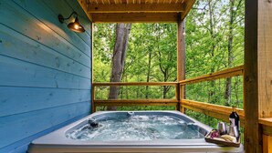 A hot tub with a wooden deck and a view of a forest. - Smokies Private Pool Cabin, Sleeps 14,Theatre & Game Room, Minutes from Parkway! (Sevierville)