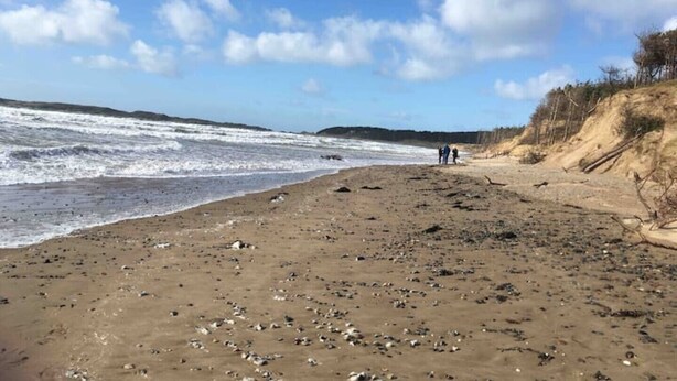 A beach with waves, a sandy shore, and a few people walking. - Benllech Sea View bungalow, Dog Friendly sleeps 6 (Benllech)