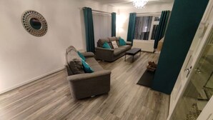 A living room with a sofa, a coffee table, and a patterned rug. - Benllech Sea View bungalow, Dog Friendly sleeps 6 (Benllech)