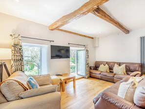 A living room with a wooden ceiling, a sofa set, a TV, and a window with curtains. - 3 bedroom accommodation in Ingleton (Ingleton)