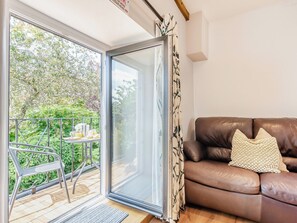 A room with a sliding glass door leading to a balcony with a table and chairs. - 3 bedroom accommodation in Ingleton (Ingleton)