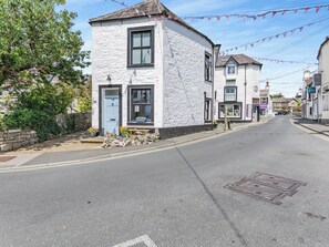 A white building with a blue door, a window, and a small bench outside. - 3 bedroom accommodation in Ingleton (Ingleton)