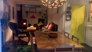 A cozy living room with a wooden dining table, chairs, a sofa, and a red lamp. - Classic Beach House Sandy Point (Sandy Point)