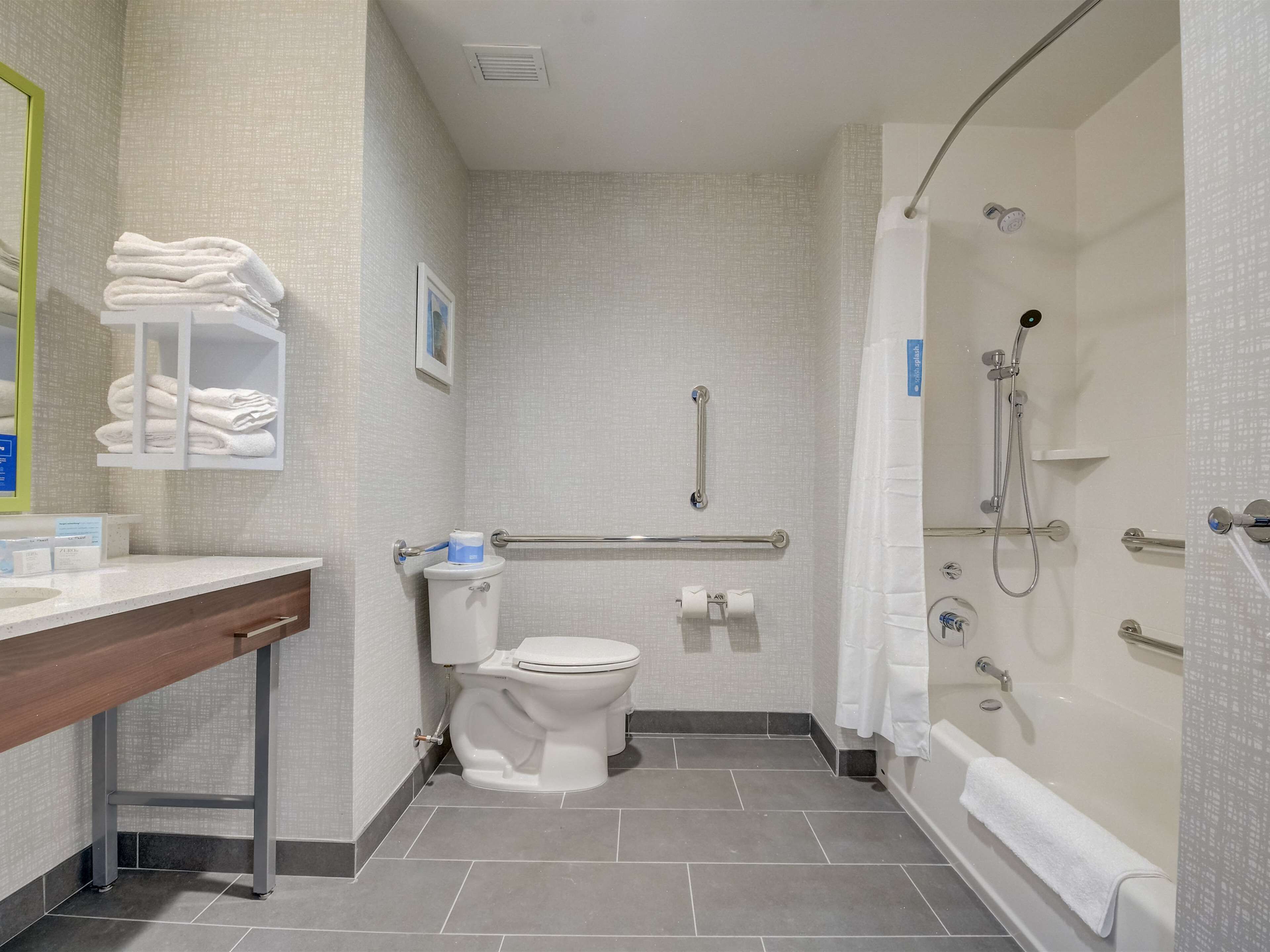 A modern bathroom with a toilet, sink, and shower.