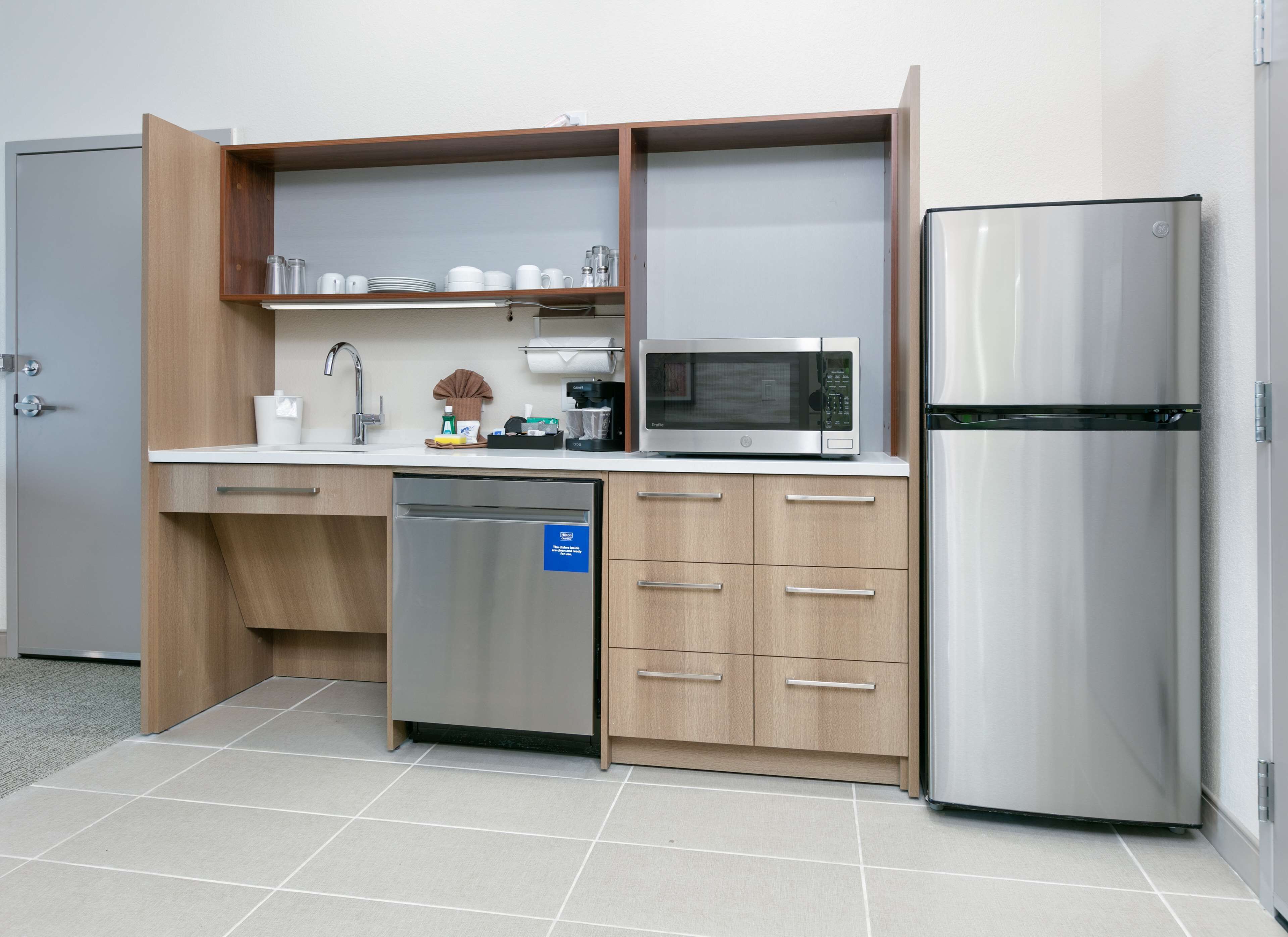 A compact kitchen with a dishwasher, microwave, and refrigerator.
