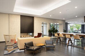 Un espace de détente moderne doté d’une cheminée, de sièges confortables et d’un bar.