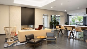 A modern lounge area with a fireplace, seating, and a bar.