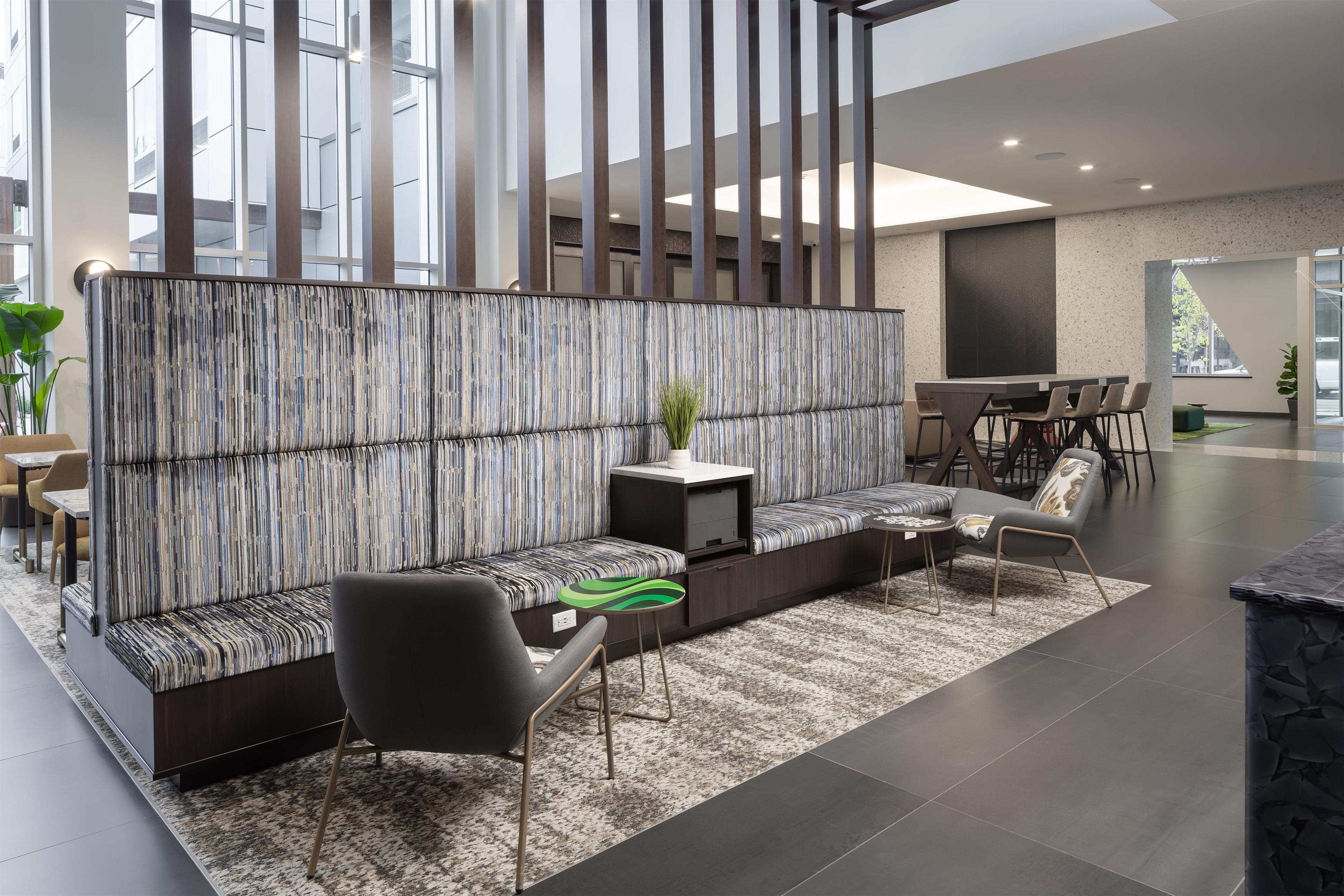 A modern interior with a sectional sofa, a small table, and a seating area with chairs.