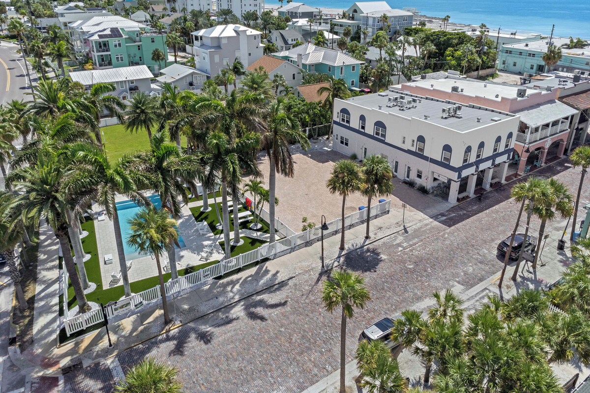 A coastal town with a prominent building featuring a central courtyard and a swimming pool.