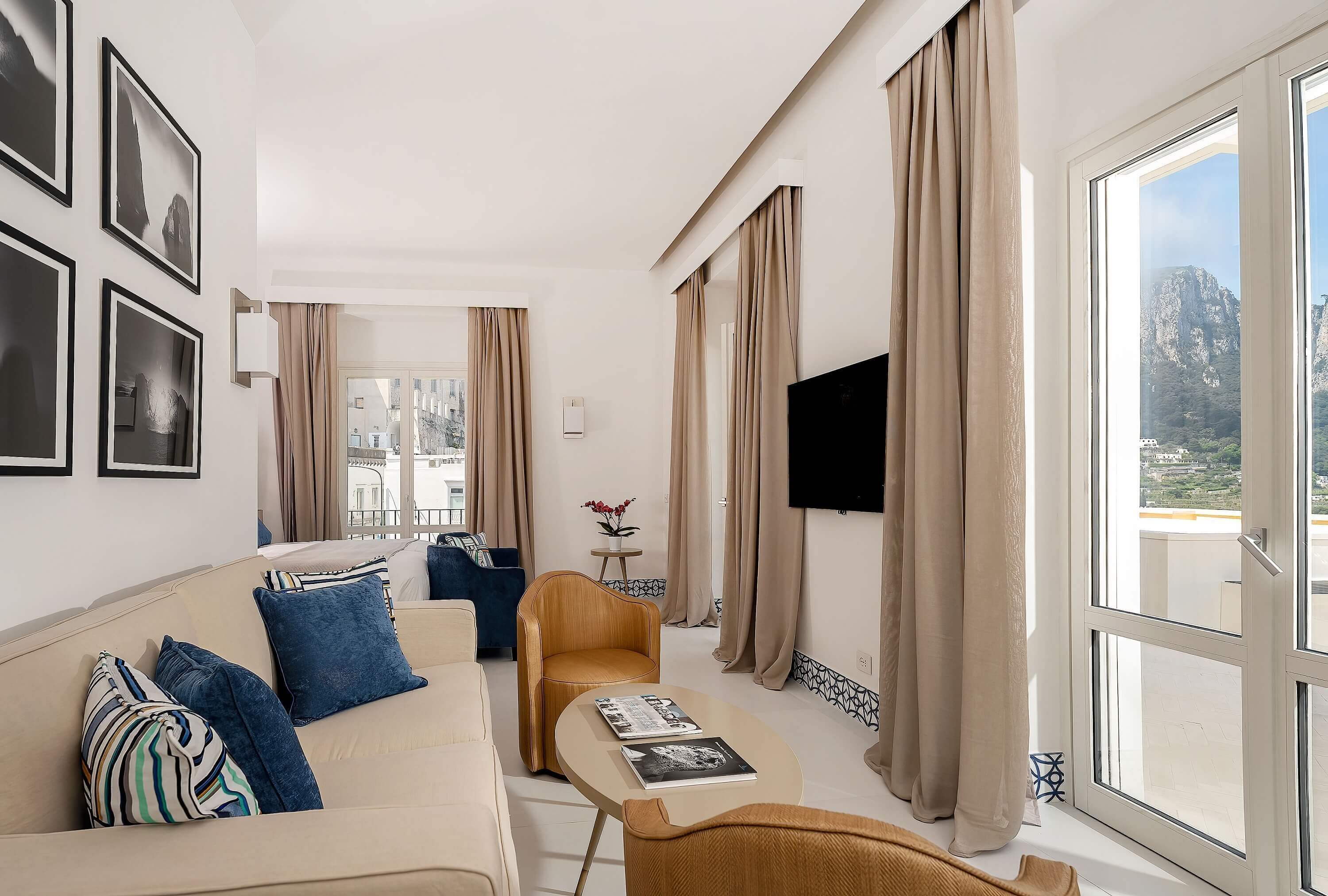 Una sala de estar moderna con un sofá, sillones, una mesa de centro y un televisor.