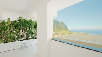 A modern room with a balcony, white walls, and a view of a coastal landscape.