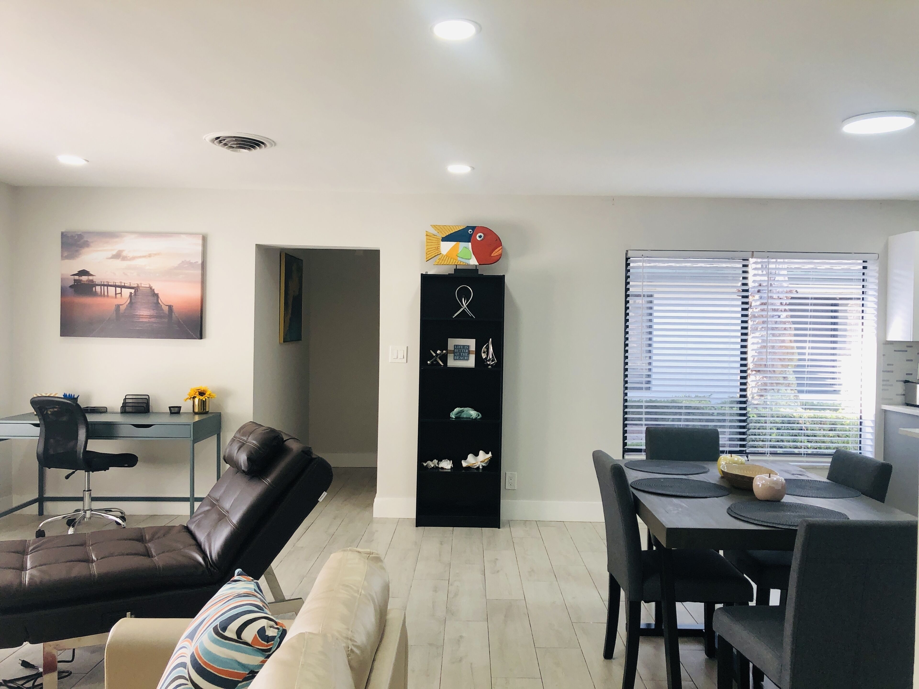 Una sala de estar moderna con un sofá, una mesa de comedor y una zona de cocina.