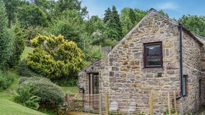Ein Haus aus Stein mit Holzzaun und Garten.
