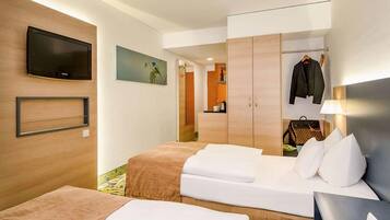 Quarto de hotel com duas camas, televisão, quadro, guarda-roupa e cabideiro.