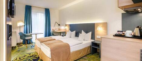 A hotel room with a large bed, a desk, a chair, a TV, and a window with curtains.