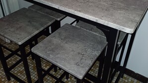 Una cocina con encimera gris, dos taburetes y una cesta con la etiqueta 'Sauveteurs De Provence'.