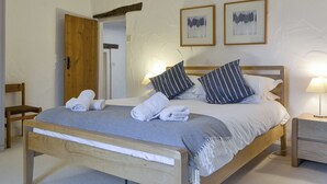 A bed with pillows, a bedside table, a chair, and two framed pictures on the wall. - 3 bedroom accommodation in Sunderland, near Bassenthwaite (Sunderland, near Bassenthwaite)