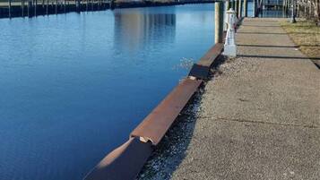 A waterfront hotel with a dock, a pedestrian path, and a clear view of the water.