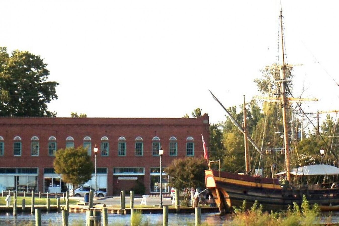 Un edificio frente al agua con un muelle y un barco.