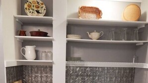 A kitchen with white cabinetry, a granite countertop, a sink, and a backsplash.
