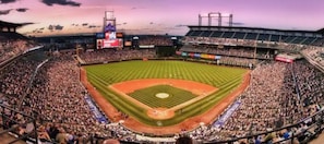 A large stadium filled with spectators, featuring a baseball diamond and multiple tiers of seating. - Cozy King by Red Rocks & Downtown Denver (Wheat Ridge)