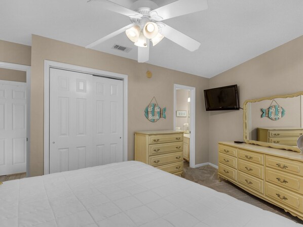 A bedroom with a bed, a dresser, a television, and a ceiling fan. - Free Beach Chair Service in Season, 2 Swimming Pools (Miramar Beach)