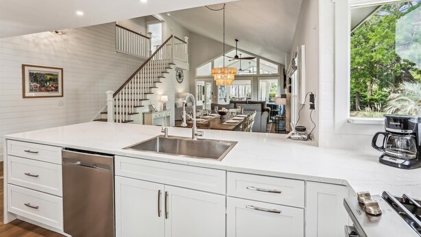 A spacious kitchen with a large island, stainless steel appliances, and a view of the outdoors.