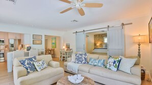 A spacious living room with two sofas, a coffee table, and a ceiling fan.
