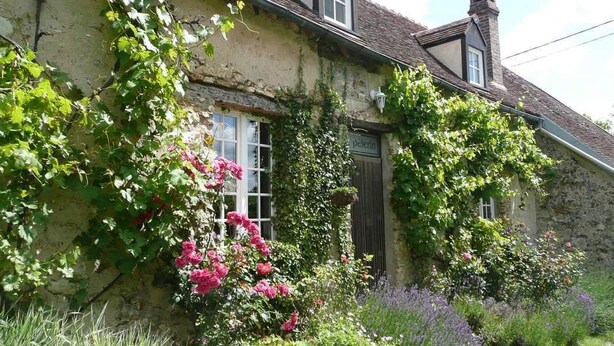 A stone building with a traditional design, a visible door, and a garden with various plants and flowers. - Le clos verdonnais  (Verdon)
