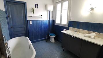 A bathroom with a bathtub, toilet, and sink.
