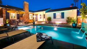 A backyard with a swimming pool, outdoor seating, and a brick house. - Pool/Hot Tub/Pet Friendly/Walk To Beach (La Jolla)
