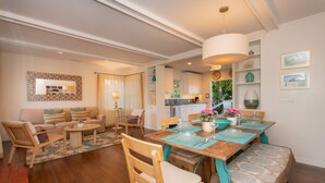 A spacious living room with a dining area, wooden furniture, and a kitchen in the background. - Pool/Hot Tub/Pet Friendly/Walk To Beach (La Jolla)
