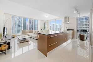A spacious living area with a large island kitchen, a sofa, and a coffee table.