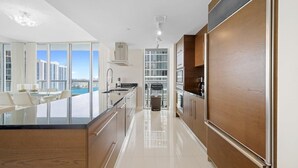 Una cocina moderna con una isla central, un comedor con vistas y un ventanal grande.