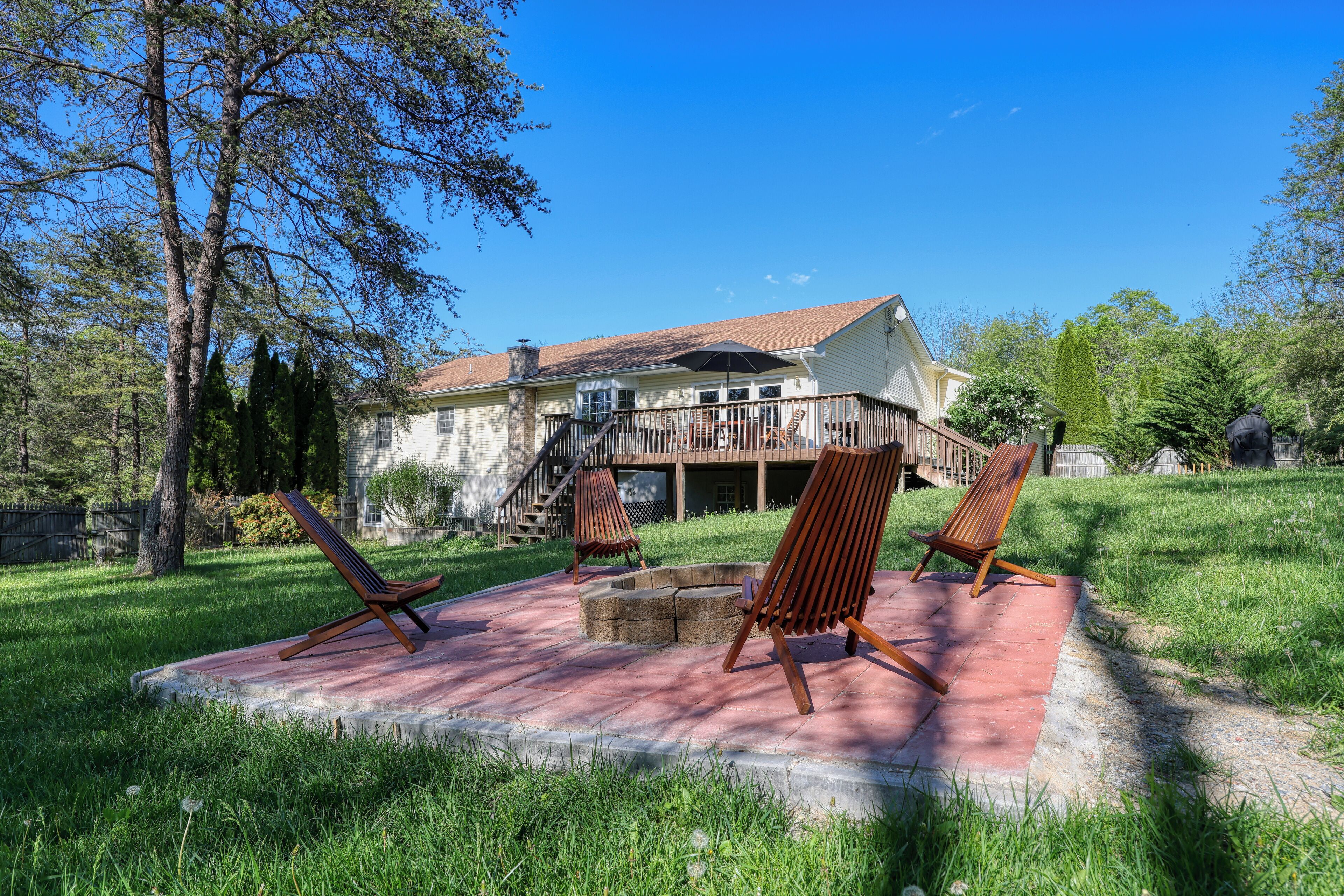 Une maison dotée d’une terrasse, d’un espace salon extérieur et d’un foyer.