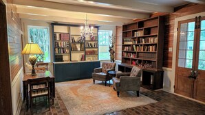 A cozy reading nook with a fireplace, bookshelves, and comfortable seating. - Marguerite Bed and Breakfast (St. Gabriel)