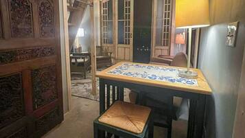 Une pièce comprenant une table et une chaise, une lampe et une porte ornée de sculptures complexes.