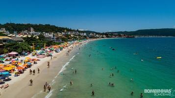 En la playa, sillas reclinables de playa, sombrillas, bar en la playa