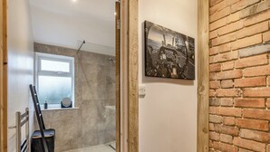 Ein modernes Badezimmer mit Dusche, Fenster und einem Bild an der Wand.