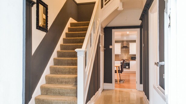 A staircase leading to a second floor with a view of a kitchen area. - 3 bedroom accommodation in Tynemouth (Tynemouth)