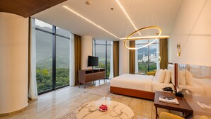 Habitación de hotel moderna con una cama grande, un escritorio, un televisor y vistas a la ciudad.