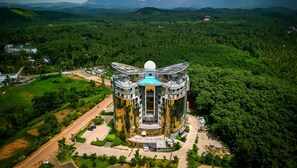 Un hotel moderno de gran altura con un atrio central rodeado de abundante vegetación.
