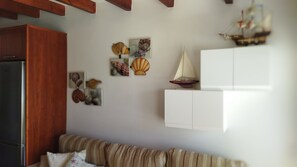 Relax in this stylish living room with a sofa, wooden cabinet, and decorative shelving unit.
