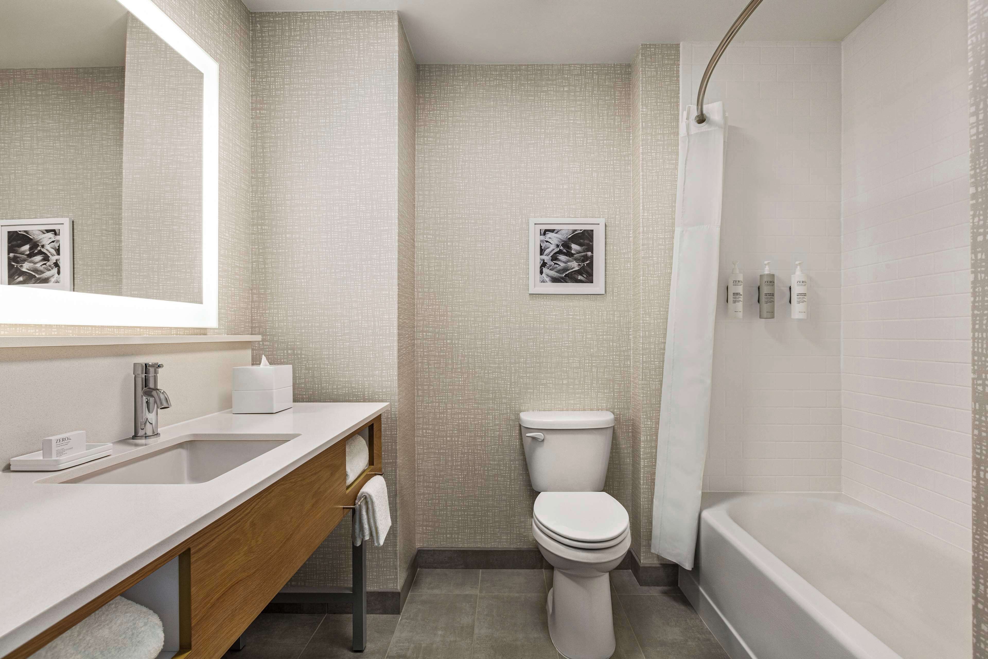A modern bathroom with a white sink, a toilet, and a bathtub.