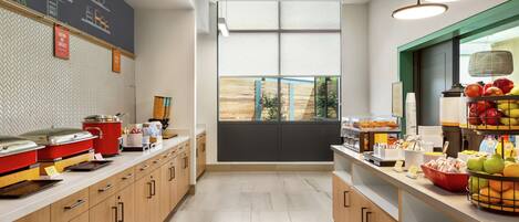 Una cocina moderna con armarios de madera, pared con pizarra y vistas a través de un amplio ventanal.