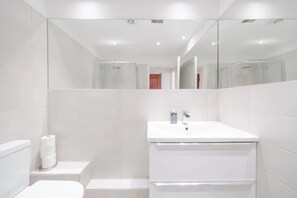 Eenvoudig appartement, 1 tweepersoonsbed | Badkamer | Een douche, handdoeken, zeep, shampoo