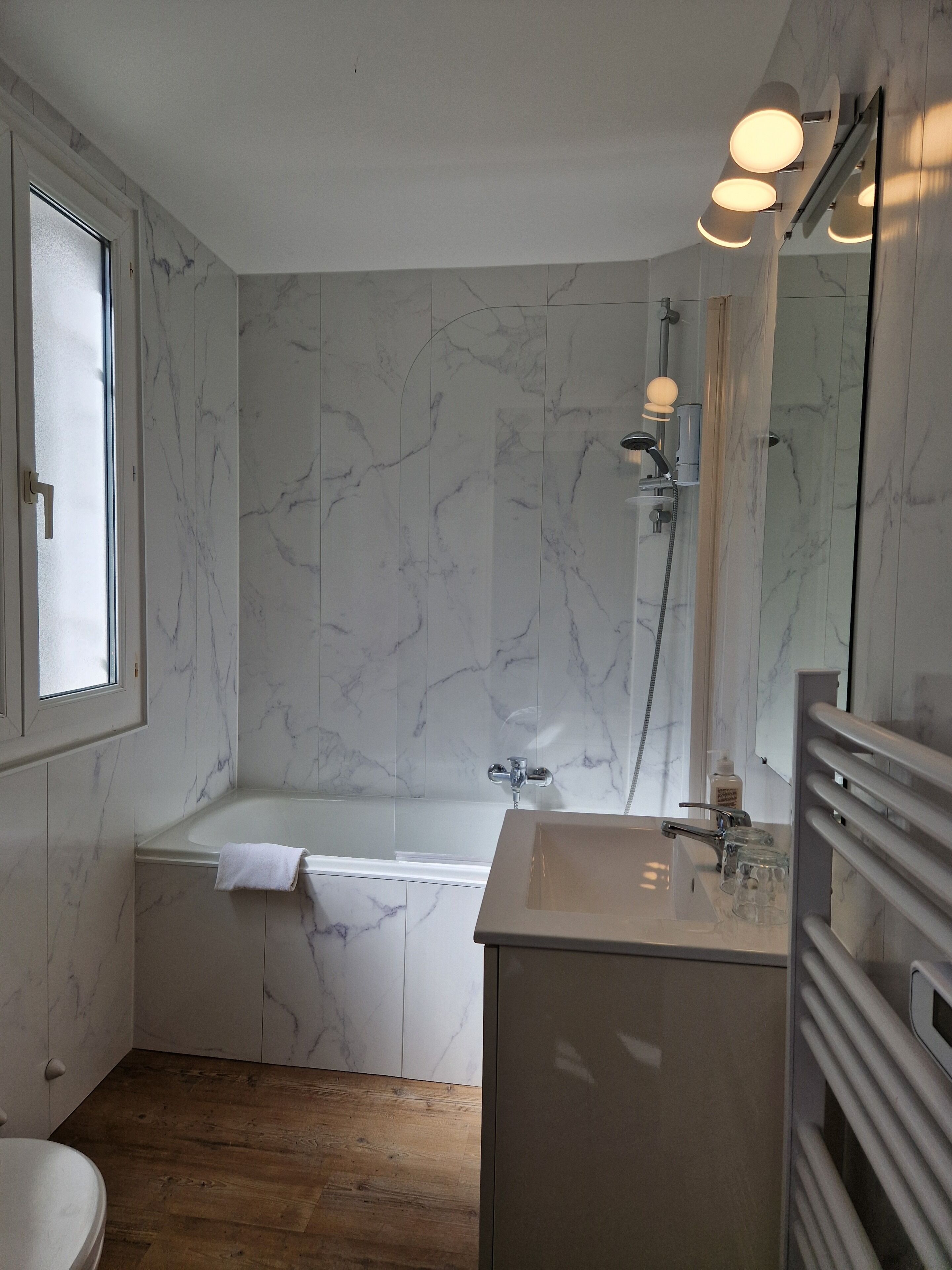 A bathroom with a bathtub, a sink, and a mirror.