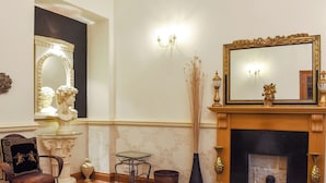A room with a fireplace, a large mirror, and classical sculptures. - 4 bedroom accommodation in Whitby (Whitby)